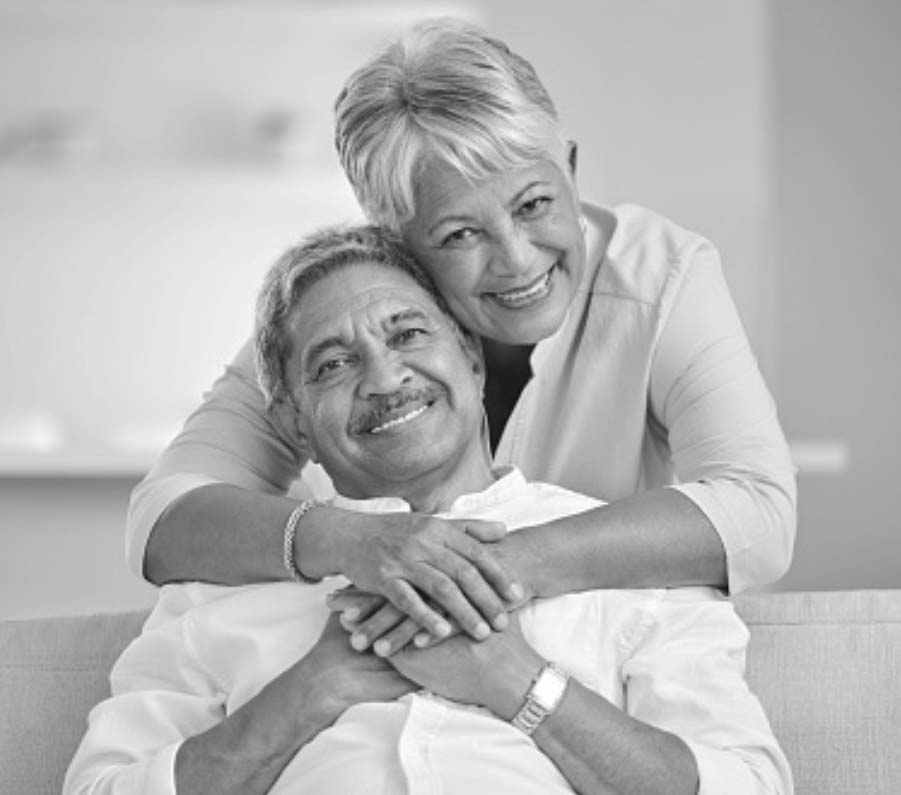 older couple smiling by a couch